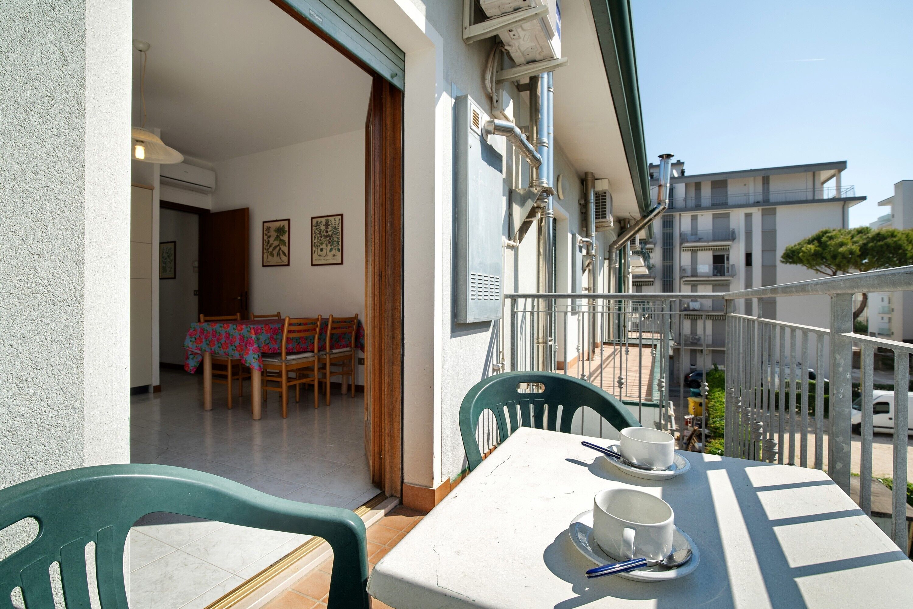 Ein Balkon mit Tisch, Stühlen und einer Essgelegenheit mit Tischdecke und Sitzgelegenheiten.