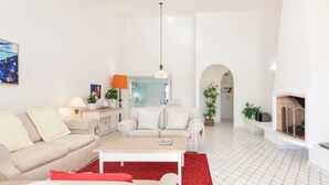 A modern living room with a sofa, coffee table, and red rug. - Villa 'Rosa' with Private Pool, Wi-Fi and Air Conditioning (Vale do Lobo)