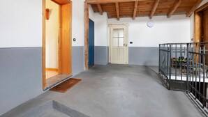 Ein Flur mit Holzboden, einer blauen Tür und einem Metallgeländer.