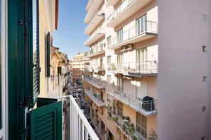 A multi-story residential building with balconies, air conditioning units, and a clear sky.