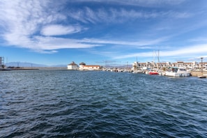 En lysthavn med tilknyttede både, en bygning med rødt tag og en klar himmel.