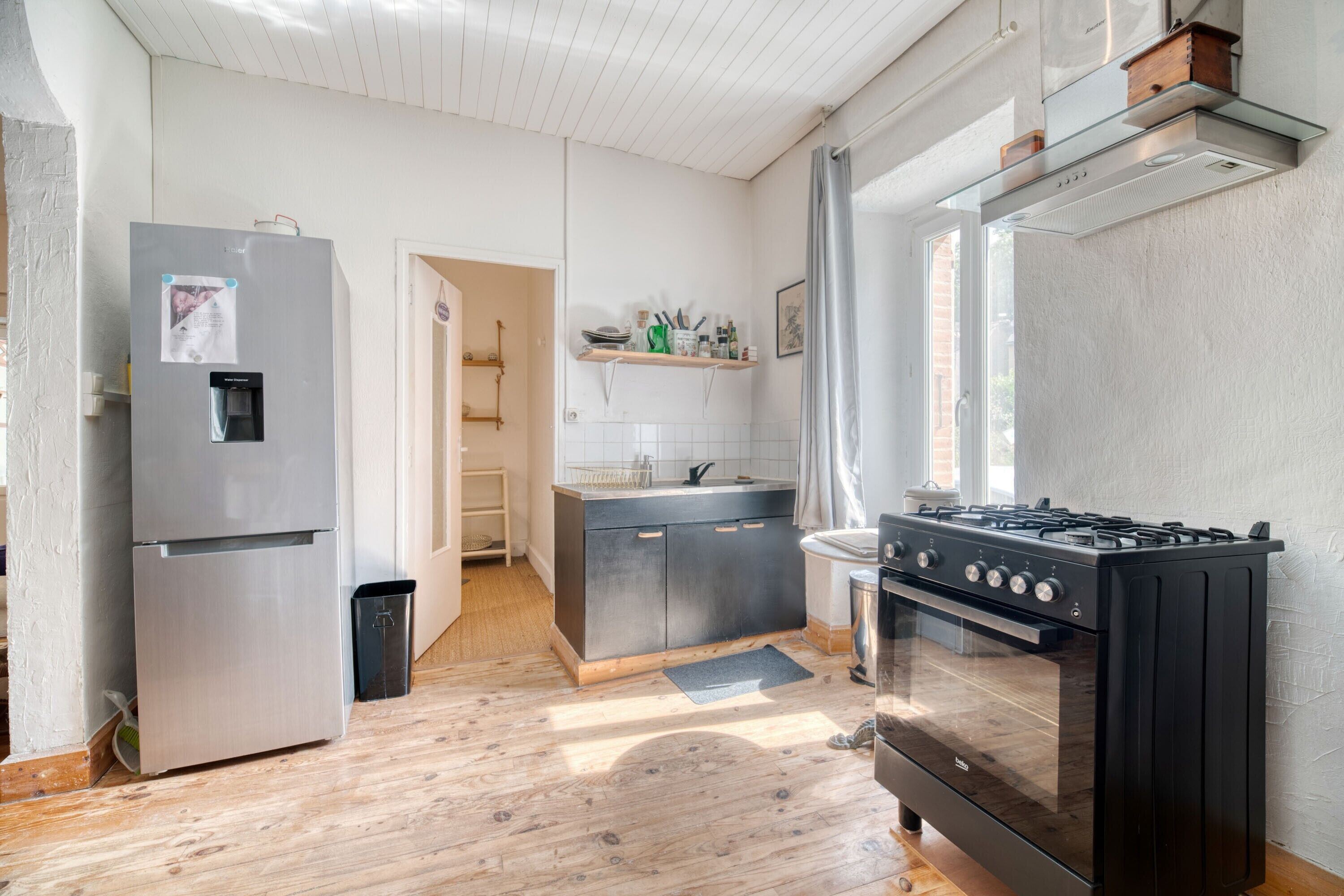 Et moderne køkken med et rustfrit stål køleskab, en gasblus og en indbygget ovn.