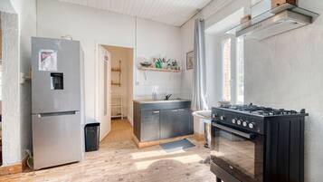 Et moderne køkken med et rustfrit stål køleskab, en gasblus og en indbygget ovn.