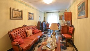 A living room with a red leather sofa, a wooden coffee table with a tray of snacks and glasses, and a lamp.