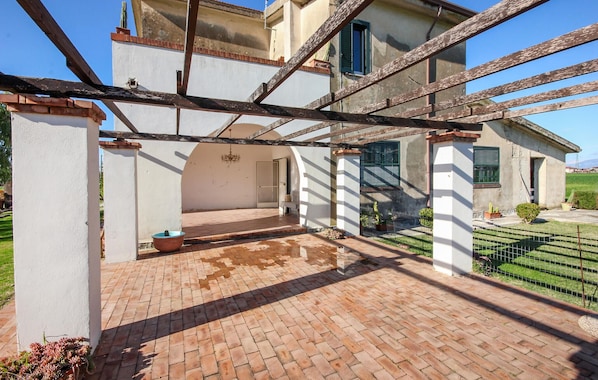 Relax in a serene outdoor space surrounded by lush greenery and a charming pergola.