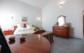 Cozy retreat with a large bed, dresser, and mirror.