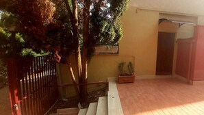 A staircase leading to a door, a small potted plant, and a metal gate. - LunaBedRoma - Short rentals in the green (Roma)