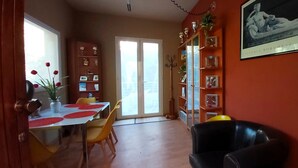 A dining area with a table, chairs, and a bookshelf. - LunaBedRoma - Short rentals in the green (Roma)