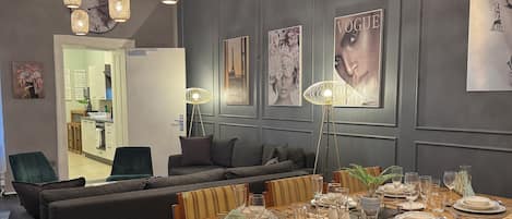 Un coin repas avec une table en bois dressée pour six personnes, entourée de chaises rembourrées.