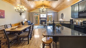 A spacious kitchen with a large island, wooden ceiling, and a fireplace. - Private Hot Tub Getaway with Peaceful Views, Free Silver Dollar Tickets & Near Branson Shows (Branson)