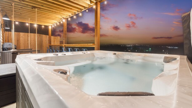 A hot tub with a cityscape view, wooden ceiling, and seating area. - Lake View Condo with Private Hot Tub, $400 Free Daily Tickets & Unique Layout (Kimberling City)