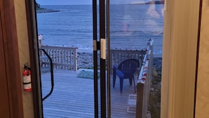 A room with a sliding glass door leading to a deck with a view of the ocean. - False Harbour Beach Paradise.
Directly on the beach.
worlds highest tides (Cape Forchu)