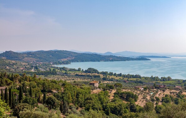 A coastal landscape with a view of the sea, hills, and scattered buildings.