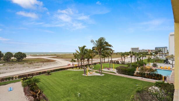 Ein Resort mit Pool, Palmen und Blick auf den Strand.
