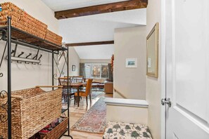 A cozy interior with a dining area, wicker baskets, and a view through a doorway. - New Ski Mtn Condo, Walk to Ski Hill - Kingswood 6C (Quechee)