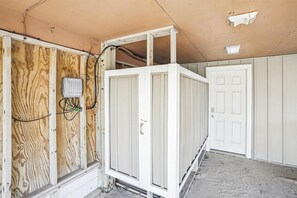Une pièce dont les murs sont recouverts de lambris en bois apparent, avec une porte blanche et un meuble blanc.