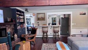 A living room with a fireplace, a dining area, and a kitchen.