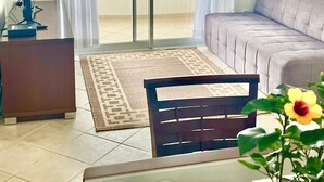 Ein Zimmer mit Balkon, einer Couch, einem Schreibtisch und einem Stuhl.