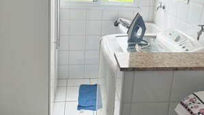 Ein kleines Badezimmer mit Fenster, Waschbecken und Dusche.