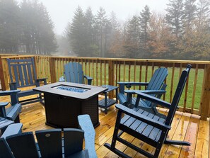 A deck with outdoor furniture and a fire feature.