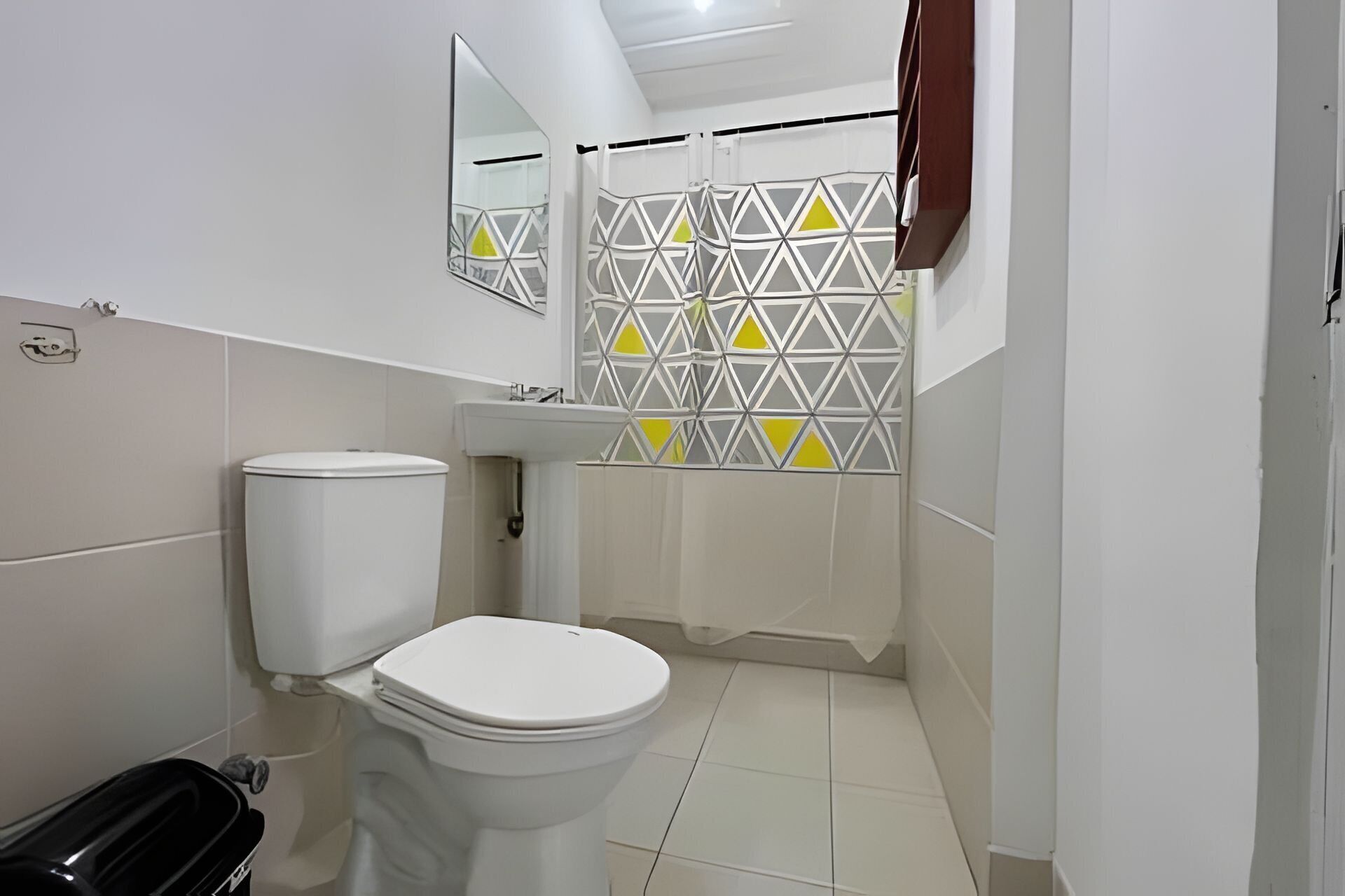 A bathroom with a toilet, sink, and shower area.