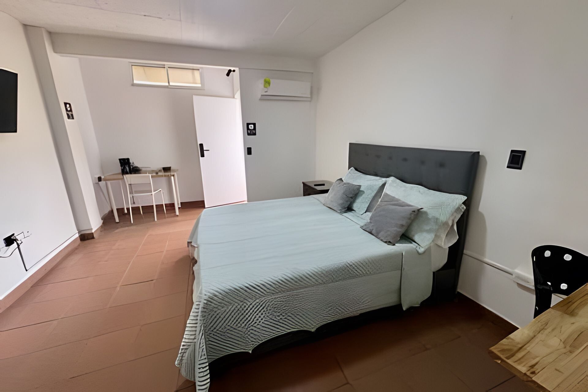 Une chambre à coucher avec un lit, un bureau et une chaise.
