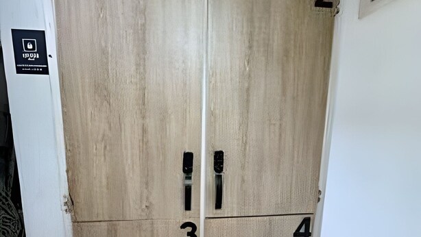 Cuatro puertas numeradas, probablemente indicando números de habitación, cada una con una cerradura de seguridad.