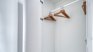 A white closet with wooden hangers and a white door.