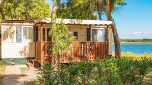 Una cabaña con cubierta de madera y vistas a un lago.