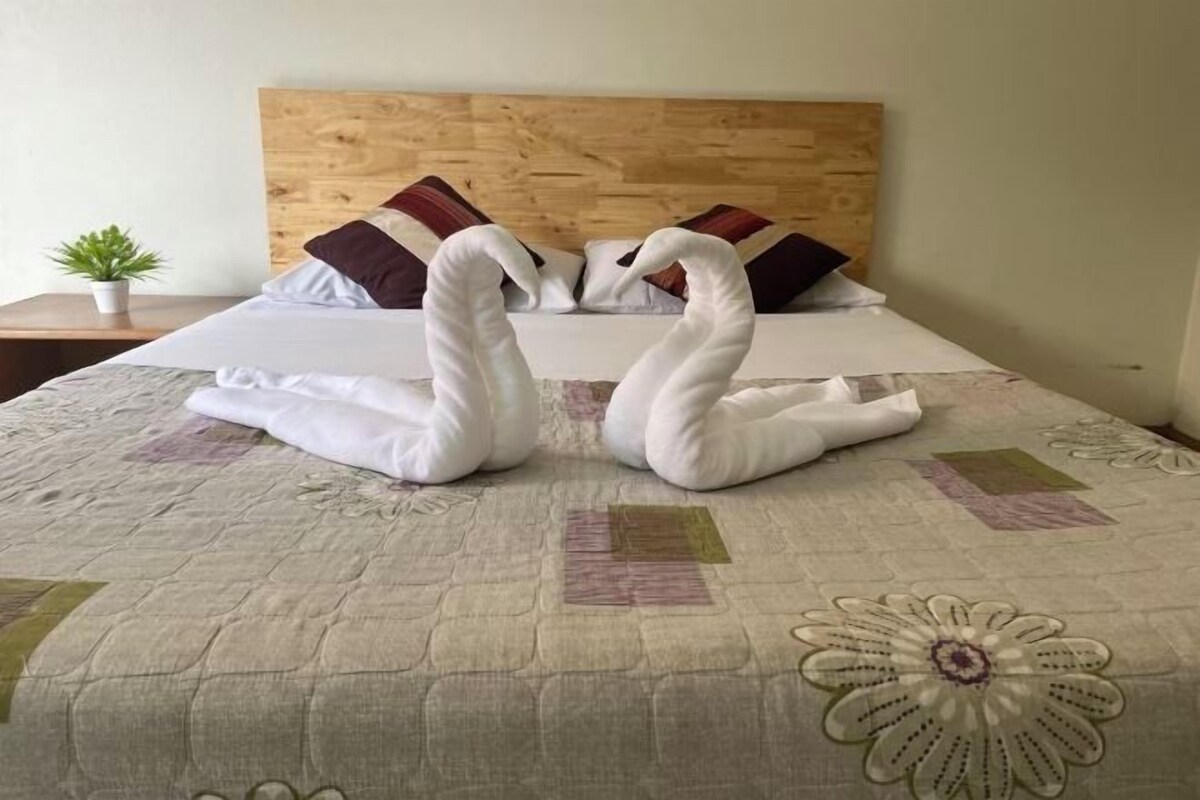 Una cama con colcha acolchada y cabecero de madera.