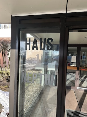 Una puerta de cristal con la leyenda 'HAUS NEPTUN', indicando el nombre del establecimiento.