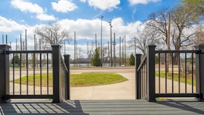 A gated entrance with a clear view of a paved area and trees.