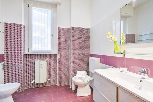 Un baño con inodoro, lavabo y espejo.