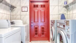 A laundry room with a red door, washing machines, and a drying rack. - 9 on the Ridge - 3 miles from Dollywood & Pet Friendly - Many repeat customers! (Pigeon Forge)