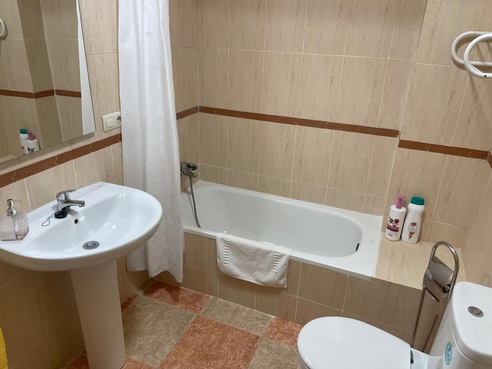 Ein Badezimmer mit Waschbecken, Badewanne und Toilette.