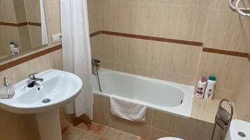 Ein Badezimmer mit Waschbecken, Badewanne und Toilette.