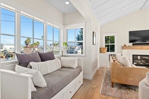A spacious living room with a large window, a fireplace, and a comfortable seating area.