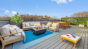 An outdoor deck with a fire pit, seating area, and a table.