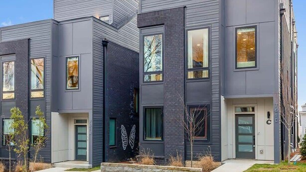 A modern multi-story building with a flat roof, large windows, and a clean, contemporary design.