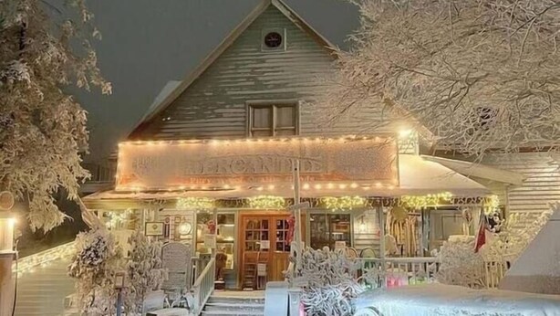 A snow-covered building with a porch, a carriage, and a sign that reads "The American Inn." - On Top Of Everything at Beech (Beech Mountain)