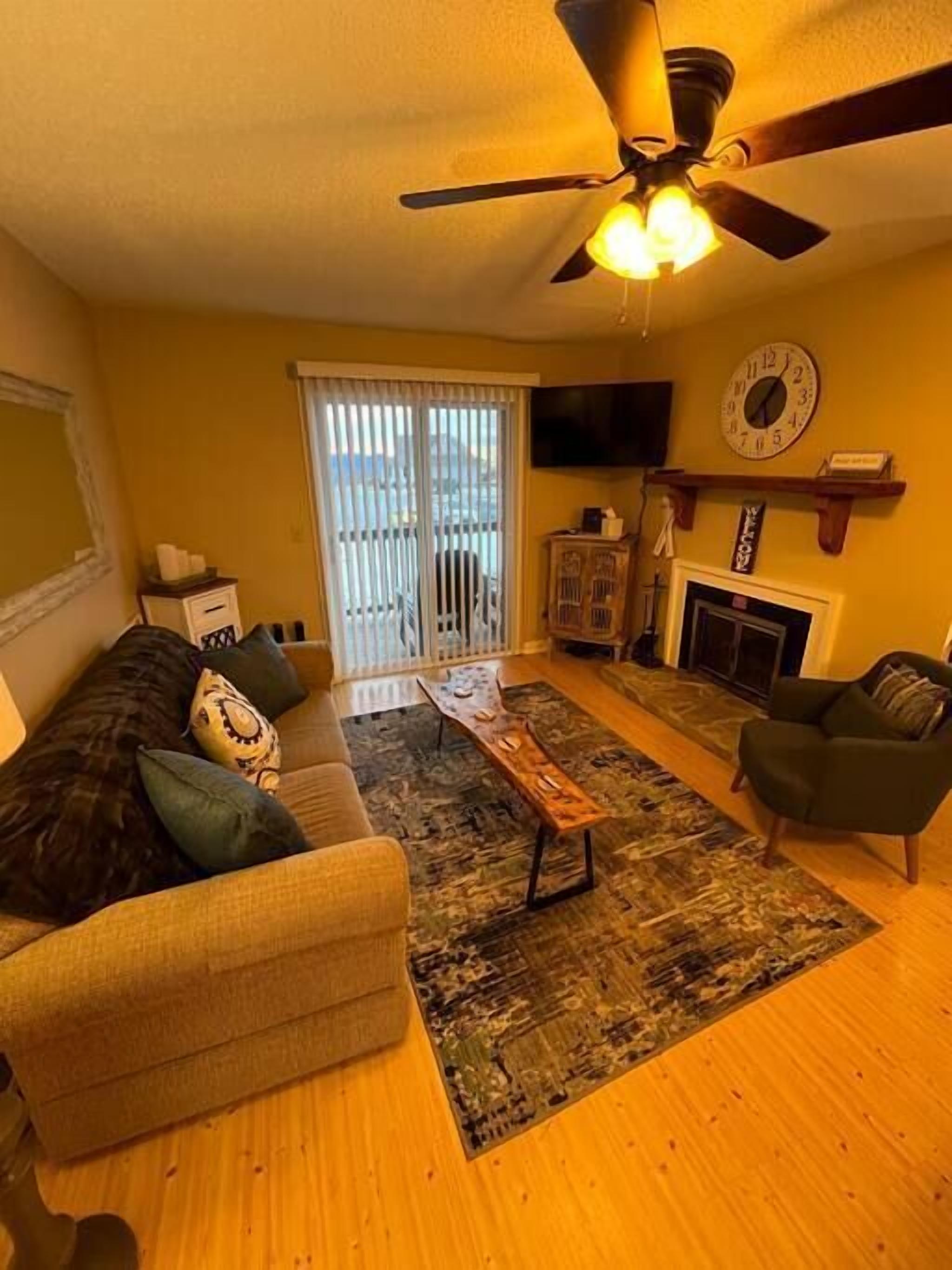 A living room with a sofa, armchair, coffee table, and a fireplace.