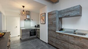 Una cucina moderna con forno integrato, lavello e parete decorata in legno.