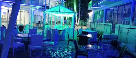 An outdoor patio area with tables and chairs, a gazebo, and a star decoration.