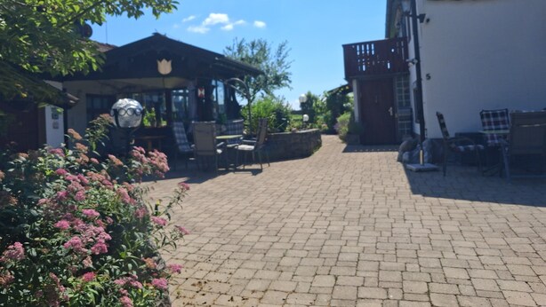 Un patio con un pabellón, asientos al aire libre y un edificio con un letrero.