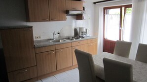 Cucina con mobili in legno, lavello in acciaio inossidabile e macchina per il caffè.