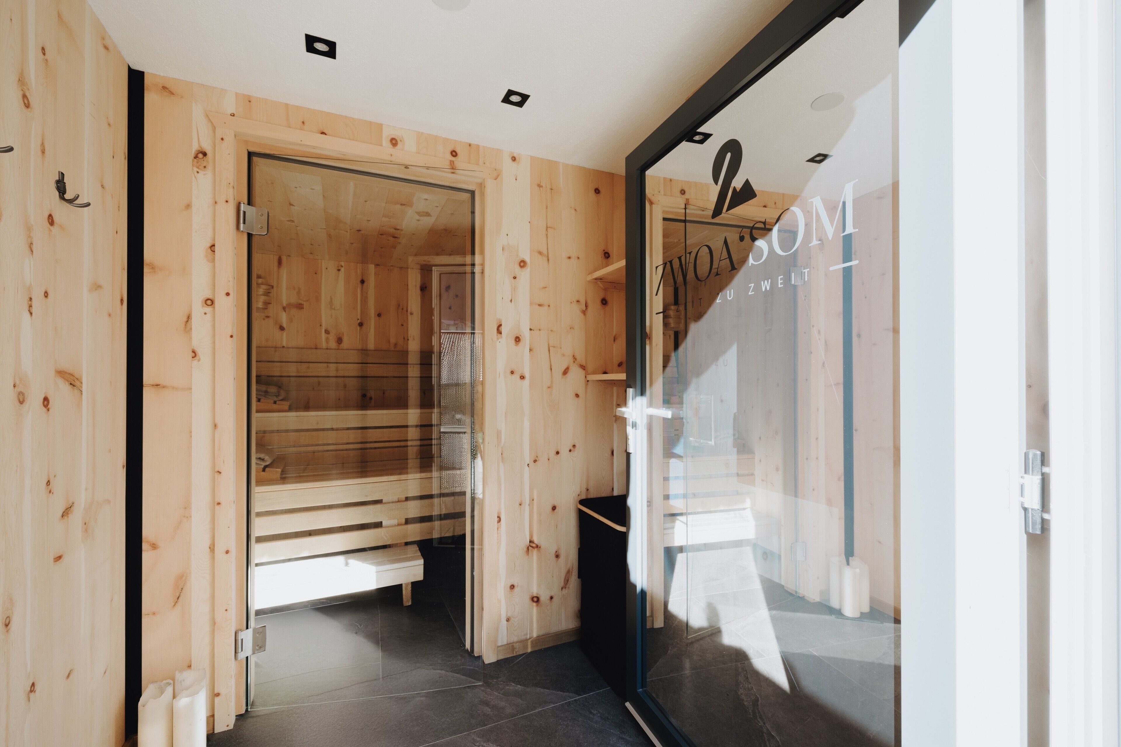 Un intérieur en bois avec une porte en verre, un banc et un logo bien visible sur la porte.