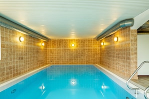 A swimming pool with tiled walls and ceiling, equipped with overhead lighting. - Vacation Apartment "Bayerwaldtraum" with Pool and Wi-Fi (Hauzenberg)
