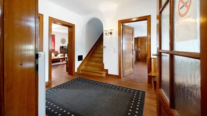 A hallway with wooden flooring, a staircase, and a mat at the entrance. - Holiday Home 'Domäne Bollinger Morbach' with Private Terrace, Private Garden and Wi-Fi (Morbach)