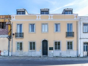 A two-story building with a central entrance, multiple windows, and balconies. - Vita Portucale | Campo de Ourique Terrace (Lisboa)