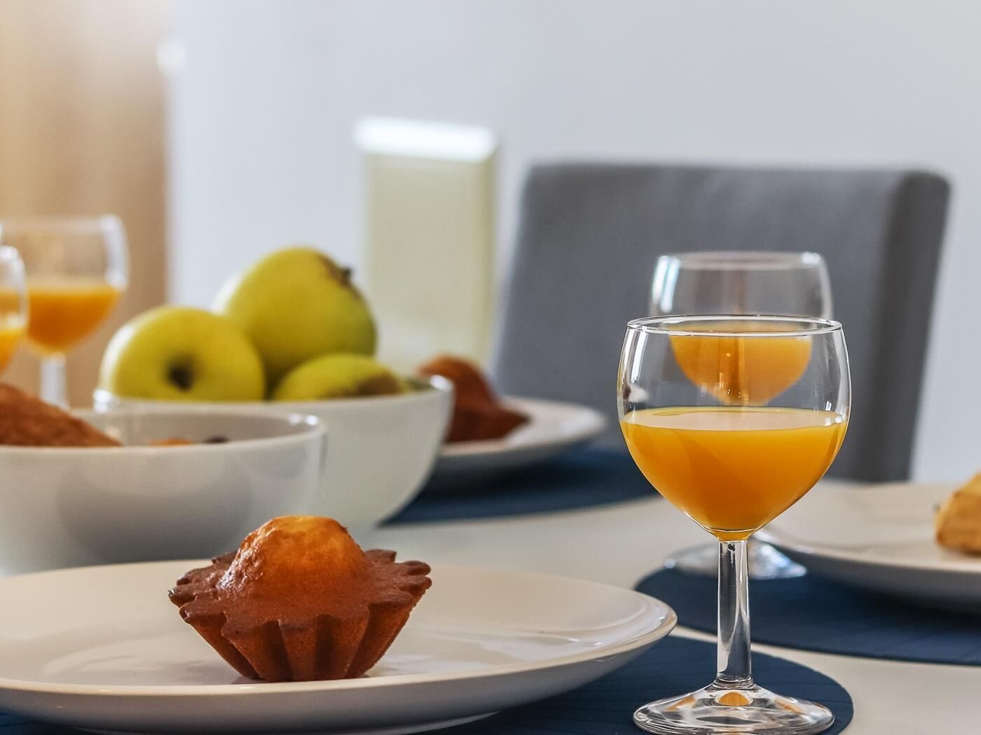 Een ontbijt met een muffin, een glas sinaasappelsap en een fruitschaal.